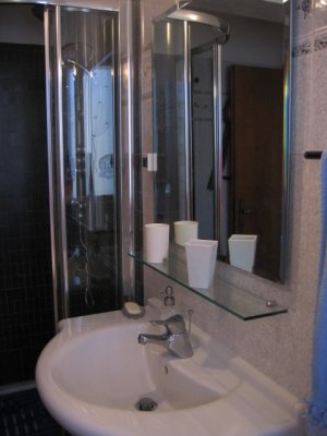 Il bagno, con doccia idromassaggio in cristallo, è in condivisione fra due stanze.